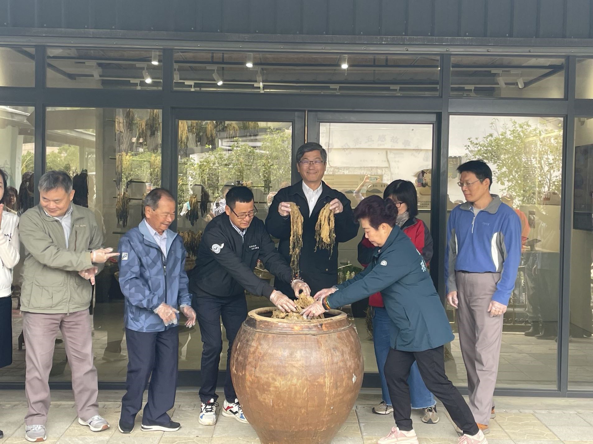 楊主委一行拿起剛開甕的醃製福菜.jpg