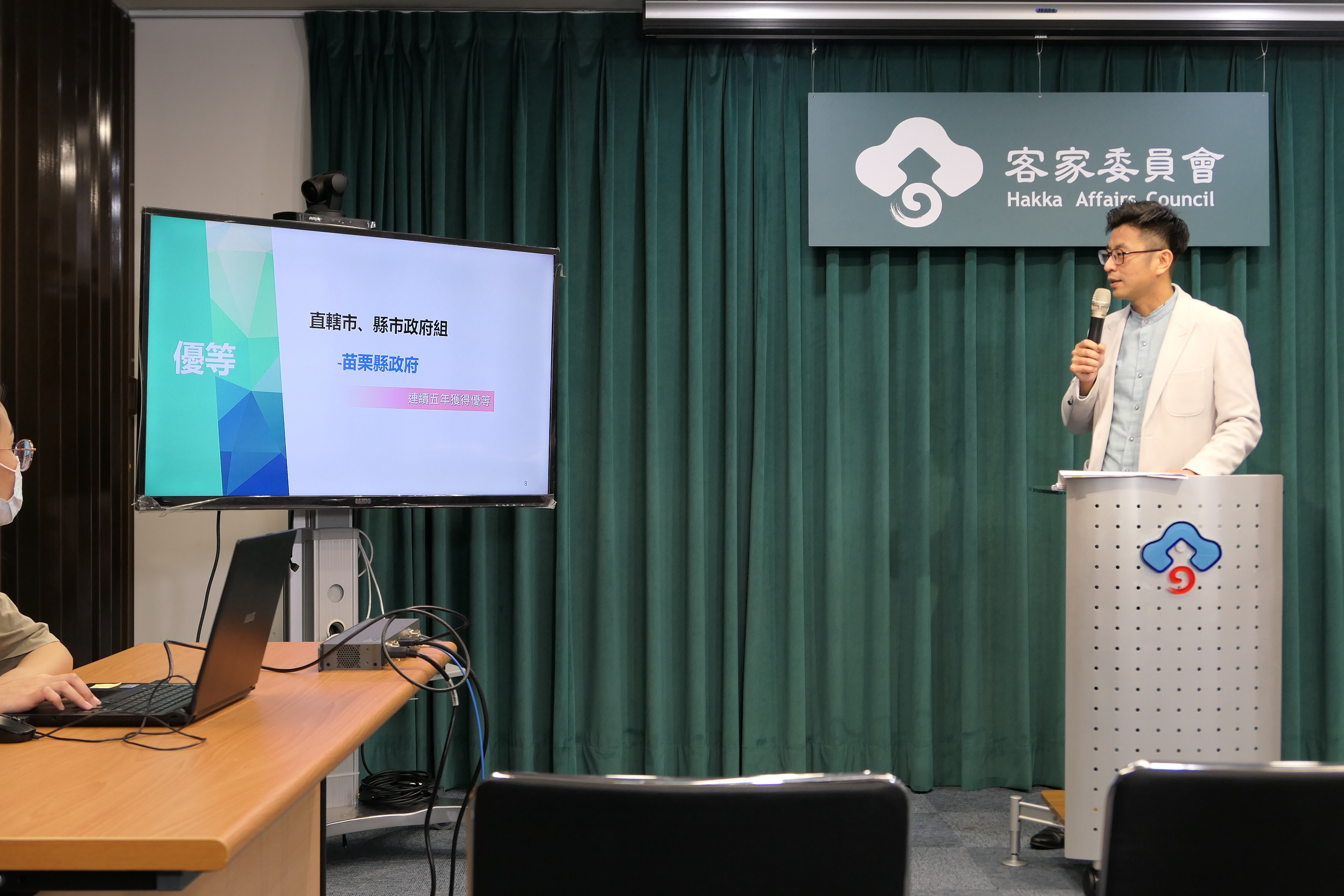 圖3周副主委揭曉苗栗縣政府於112年度第5次榮獲「推動客語為通行語成效評核」優等殊榮.JPG